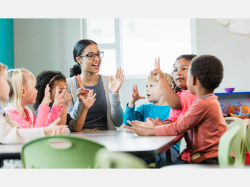 Young students learn to count from a teacher in a classroom