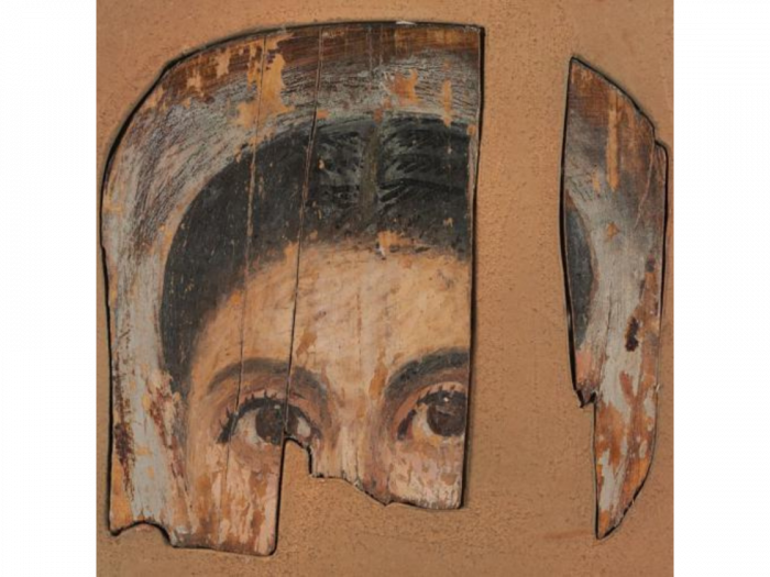 Portrait of a woman with brown eyes and dark hair on a fragmented wooden panel.
