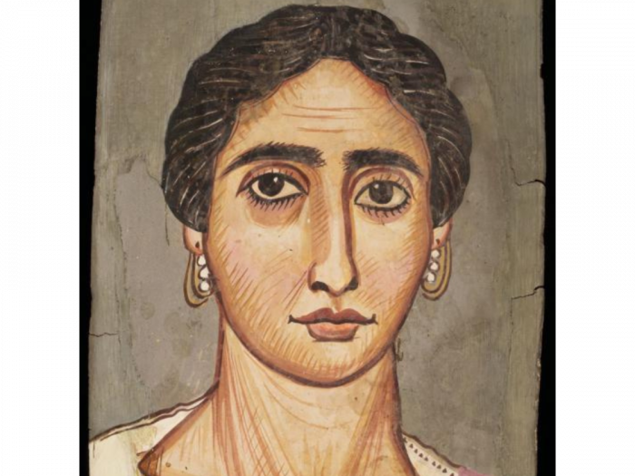 Portrait of a woman with brown eyes, black hair, and a white garment on a rectangular wooden panel.