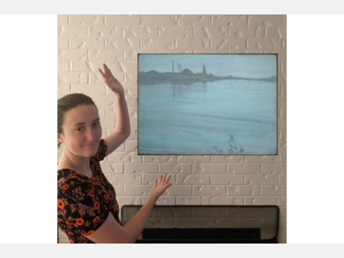 A young woman gestures toward a floating landscape painting over a mantle. The work is an almost abstract composition in silvery blues and grays.