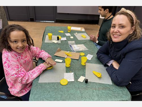 Family sitting at a table doing an activity with clay.