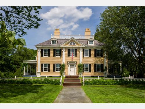 The front of a yellow Georgian mansion