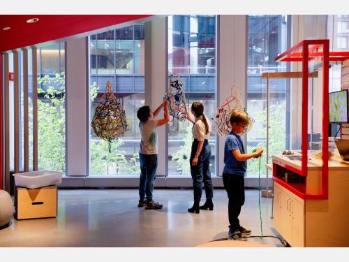 Young museum visitors work on a making activity outside of our Maker Hub. 