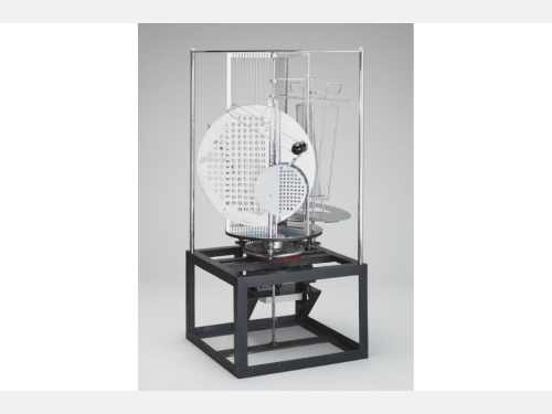 This black and white photograph shows a contemporary sculpture comprising several metal discs and rods of varying shapes.