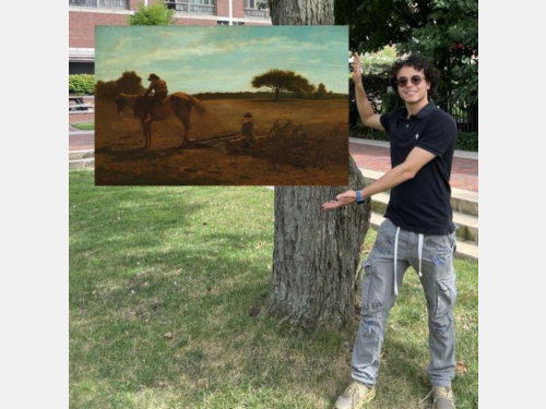 In this photomontage, a smiling young man stands next to a tree, gesturing toward a landscape painting that appears to float. In the foreground of the painting, two boys and a horse clear a large brown field. 