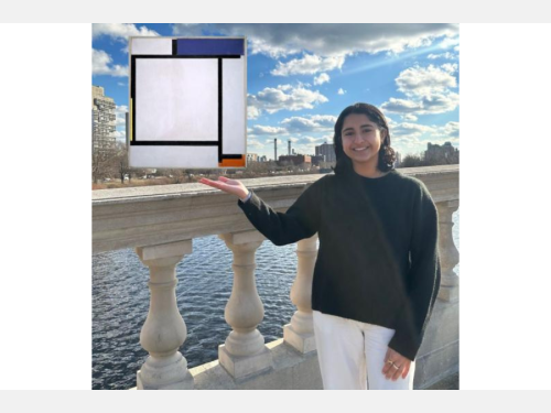 A smiling young woman, wearing a black sweater and white pants, stands on a bridge with a view of a city behind her. She is gesturing toward an abstract painting that appears to float. The painting consists of several flat planes with thick black lines that border mostly white space; three small spaces are filled in with blue, red, and yellow.