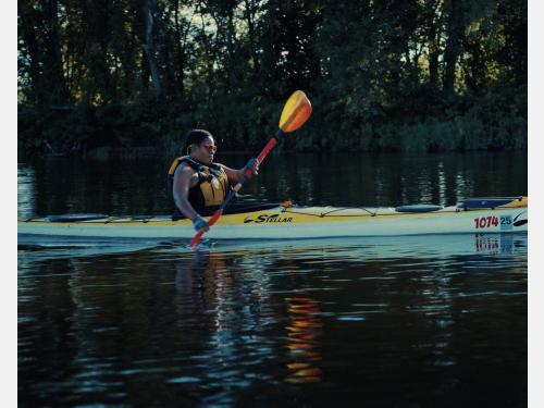 Still from Mother River depicting a black woman with short cropped hair in a kayak