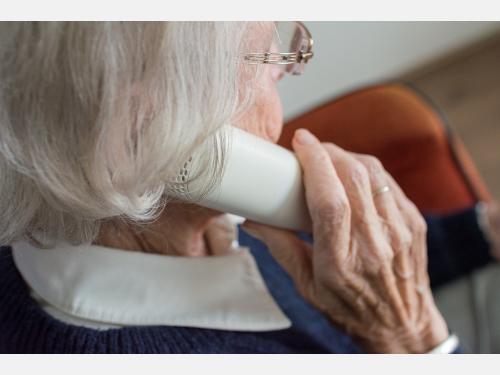 Photo of a senior adult using a telephone.