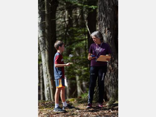 Woman holding a map and speaking with child.