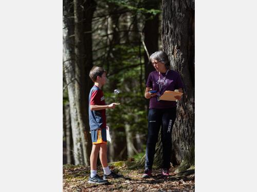 Woman holding a map and speaking with child. 