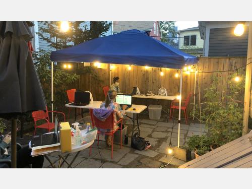 Evening in the backyard, two women on computers, socially distanced.