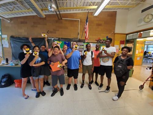 A group of 11 campers display a craft at Camp Rainbow