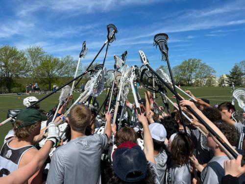 Group of lacrosse players in a huddle.