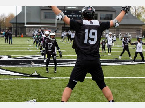 Photo of lacrosse player leading an jumping jacks exercise.