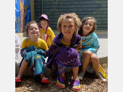 Photo of children wrapped in towels at the beach during Outback Summer Program.